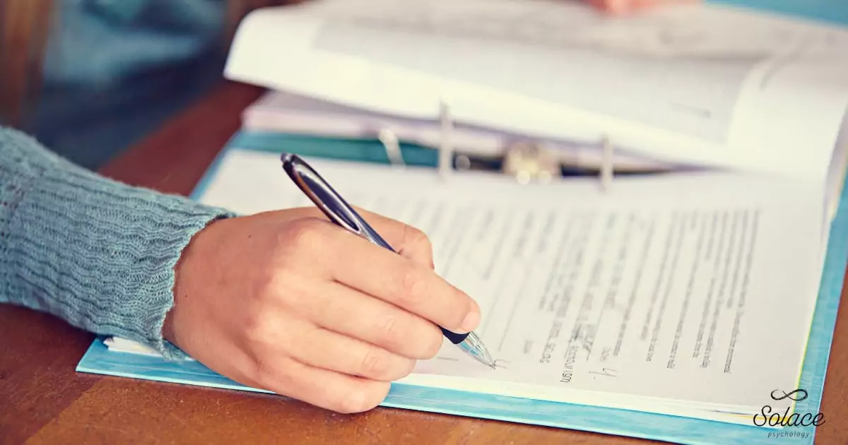psychologist-writing-assessment-report-additional-testing-reporting-fees-adhd Psychologist writing detailed reports during additional testing and reporting for an ADHD assessment.